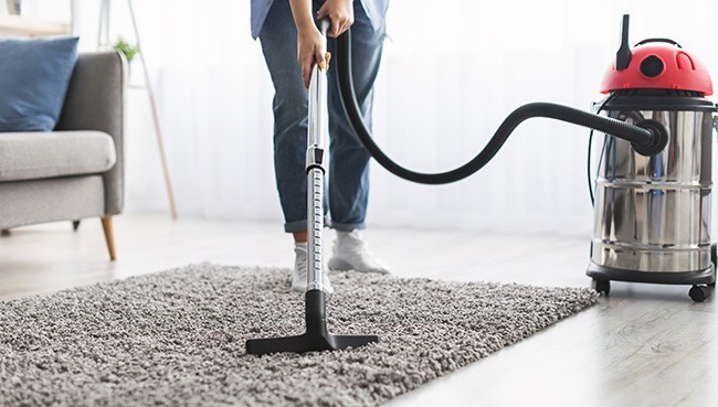 Young casual lady using vacuum cleaner | Towne Flooring Center